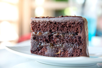 Delicious chocolate cake on White plate in cafe.