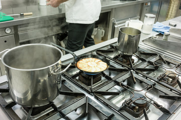 Apple pie in pan on stove in kitchen of restaurant