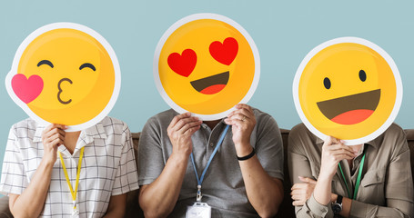 Cheerful people holding emoticon icon