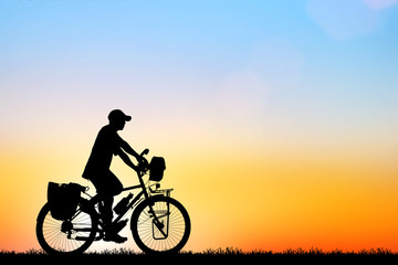 Obraz na płótnie Canvas Silhouette man and bike relaxing on sunrise