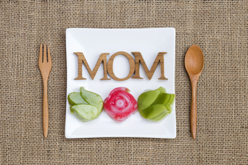 Sweet Mother's day concept, mom kitchen, Thai layer cake in flower shape with mom wooden text on...