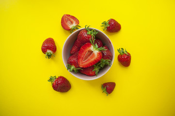 Strawberry in a bowl on yellow background.