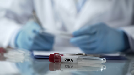 Laboratory assistant writing results of Zika virus research, disease control