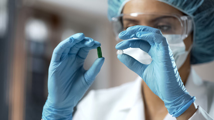 Pharmacology expert comparing two pills, analyzing medical research results