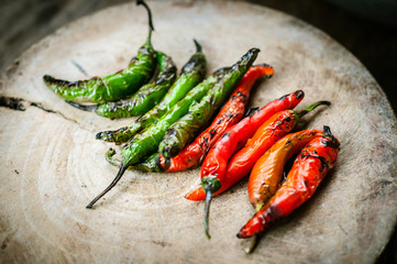 Green and red chili on chopping block