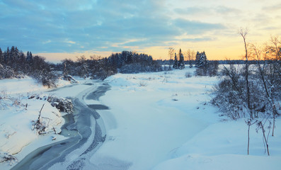 Serene winter landscape with snow covered trees and ice-bound river.Vintage colors.