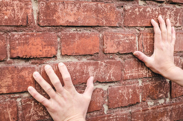 Male hands rested against the brick wall and tried to move it forward. Deadend.