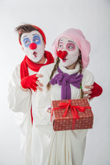 emotional mime guy and girl holding a gift. Human emotions: greed, joy and curiosity