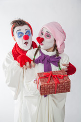 emotional mime guy and girl holding a gift. Human emotions: greed, joy and curiosity