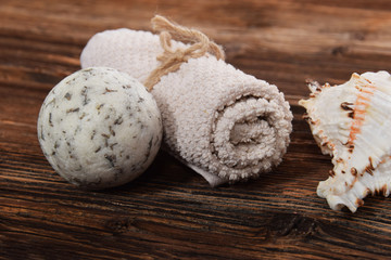 scented white bath ball white towel and scallop on a brown background