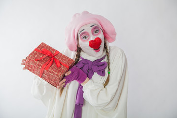 emotional mime girl holding a gift. Human emotions: joy and curiosity