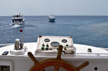 Ship with wooden steering wheel and navigation console at the helm of a yacht or motor boat,...