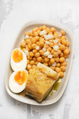 cod fish with chick pea and boiled egg on dish