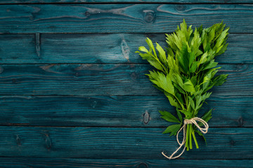 The leaves of celery. On a wooden background. Top view. Copy space.