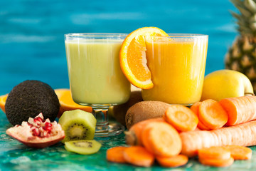 Front view of two glasses with detox smoothies next to fruits and vegetables