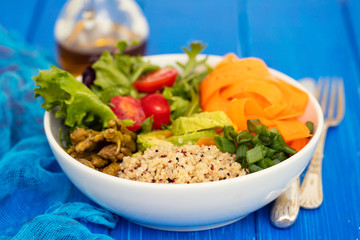 vegetables with quinoa in white bowl on dark background