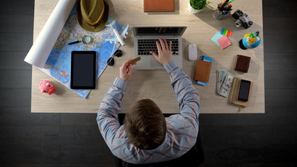 Man booking tickets and room, making advance payment online, internet shopping