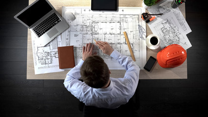 Representative of construction company preparing drawing of office building