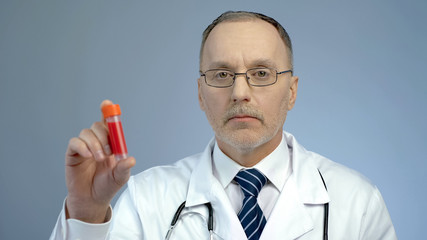 Doctor holding vial with donated blood sample for analysis, HIV awareness
