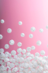 French vanilla meringue cookies on pink background with copy space.