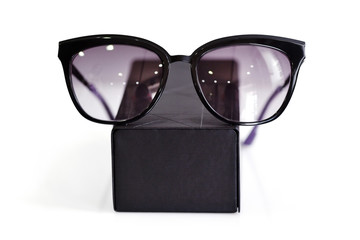 Fashionable sunglasses with box on white background