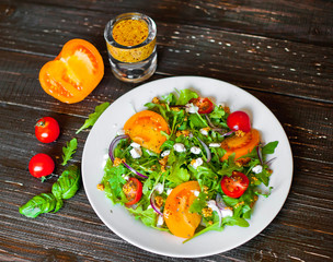 Fresh salad with tomatoes, mixed greens ,nuts, eggs, on wooden background . Healthy food.