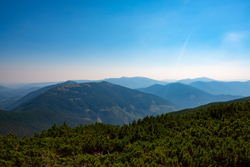 Obraz premium Wooded hills and green valleys under blue sky