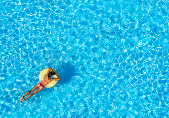 Slim woman floating on air ring in the pool