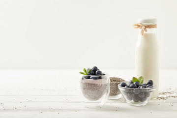 close up view of chia pudding and ingredients on white wooden surface