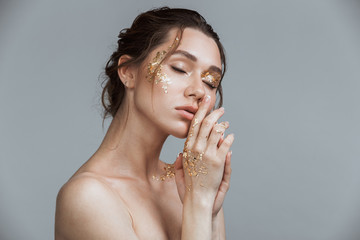 Brunette woman with soft healthy skin and golden makeup