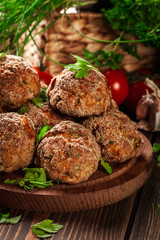 Stack of baked meatballs on a chopping board