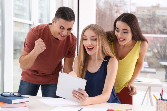 Excited students finding out their excellent grades for exam indoors