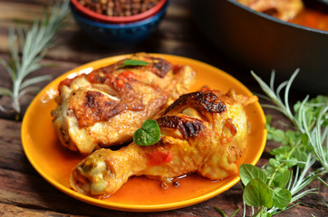 Chicken legs on an orange plate on wooden background