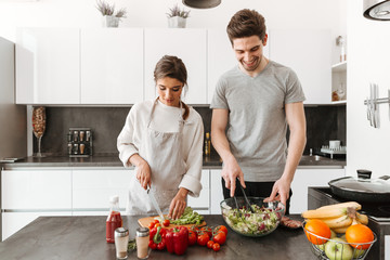 Portrait of a happy young couple cooking salad