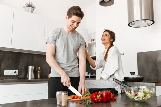 Portrait Of A Joyful Young Couple Cooking Together