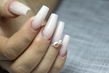 Bride's hands with simple manicure with a little jewel on the nail