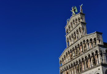 Fototapeta premium Saint Micheal in Foro Church beautiful medieval romanesque facade in the city of Lucca, Tuscany, erected in the 13th century (with blue sky and copy space)