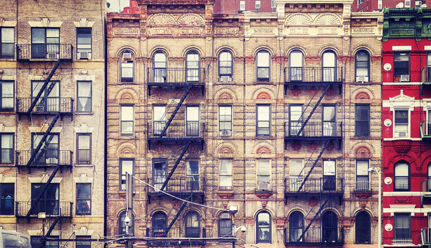 Vintage stylized picture of old buildings with fire escapes, one of New York City symbols, USA.