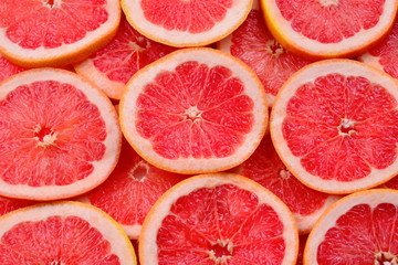 Grapefruit red juicy slices background. top view