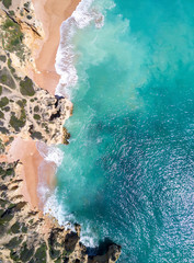 Aerial view of sandy beach and ocean with beautiful clear turquoise water.
