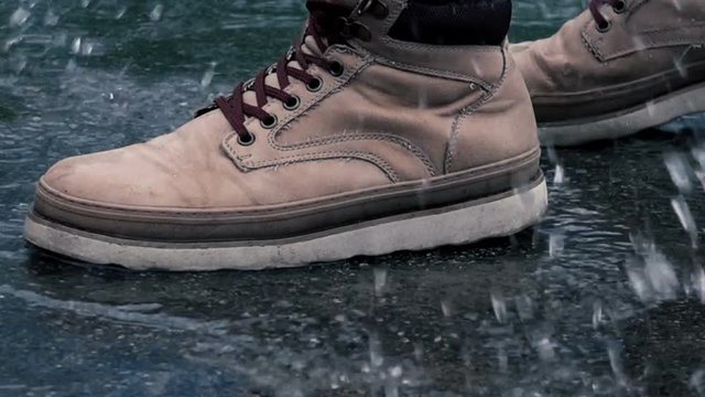 Close-up View of Man in Boots Step on a Puddle and Create a Splash in Slow Motion
