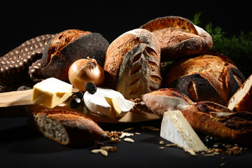 Assortment of baked bread,  cheese and olives