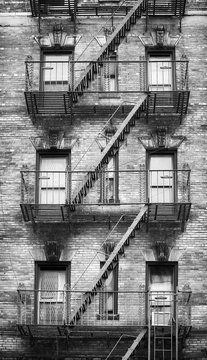 Fototapeta Black and white picture of fire escapes, one of the New York City symbols, USA.