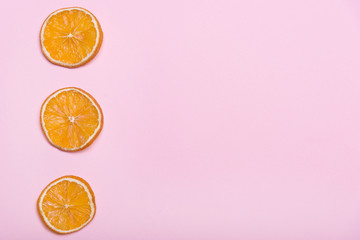 Pieces of orange. Circles with orange. Pink background. Citrus fruits.