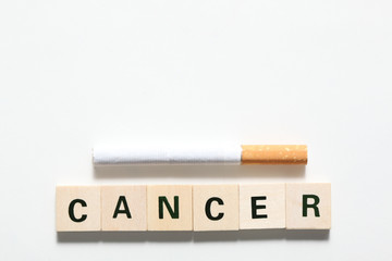 word cancer made of wooden  block and a cicarette isolated on white background