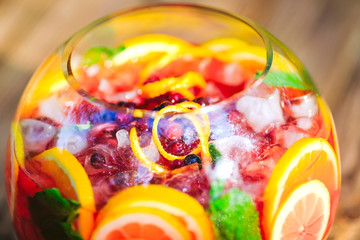 Fototapeta na wymiar Summer cocktail. Fruit cocktail on green background. Citrus fruits, berries, strawberries, blueberries, mint, ice.
