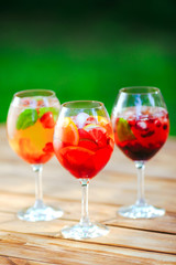 Summer cocktail. Fruit cocktail on green background. Citrus fruits, berries, strawberries, blueberries, mint, ice.