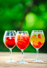 Summer cocktail. Fruit cocktail on green background. Citrus fruits, berries, strawberries, blueberries, mint, ice.