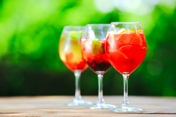 Summer cocktail. Fruit cocktail on green background. Citrus fruits, berries, strawberries, blueberries, mint, ice.