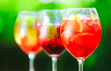 Summer cocktail. Fruit cocktail on green background. Citrus fruits, berries, strawberries, blueberries, mint, ice.